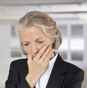 Concerned woman with hand covering mouth