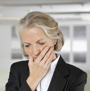 Concerned woman with hand covering mouth