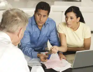 Debtors talking at a desk with a debt collection defense attorney