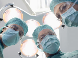 surgeons looking down at patient from patient's perspective